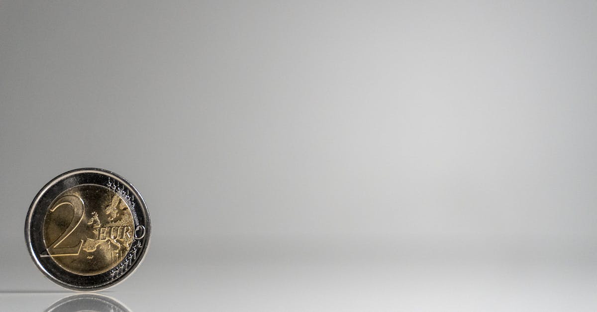 A coin on a white surface with a reflection
