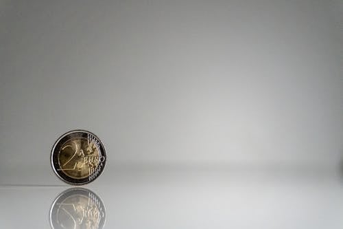 A coin on a white surface with a reflection