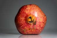 Vibrant pomegranate showcasing its rich red color and detailed texture, perfect for food photography.