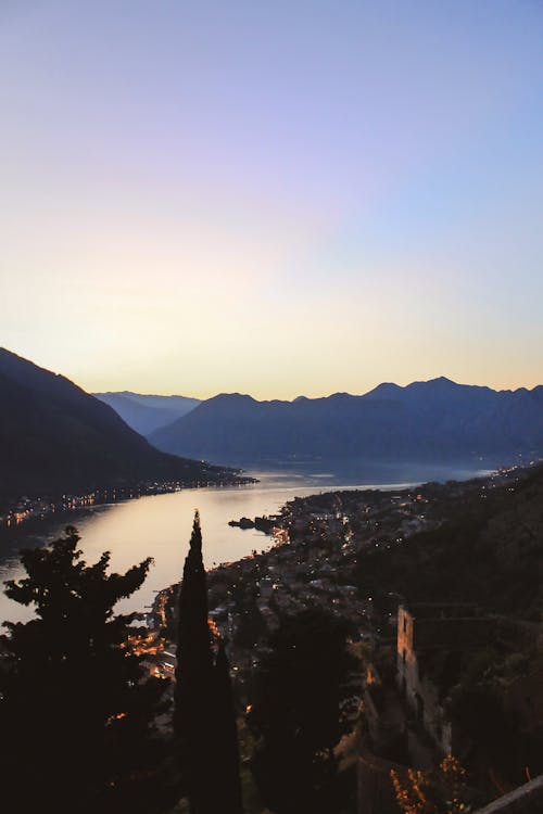 Edifici Della Città Vicino Al Fiume Con La Distanza Delle Montagne