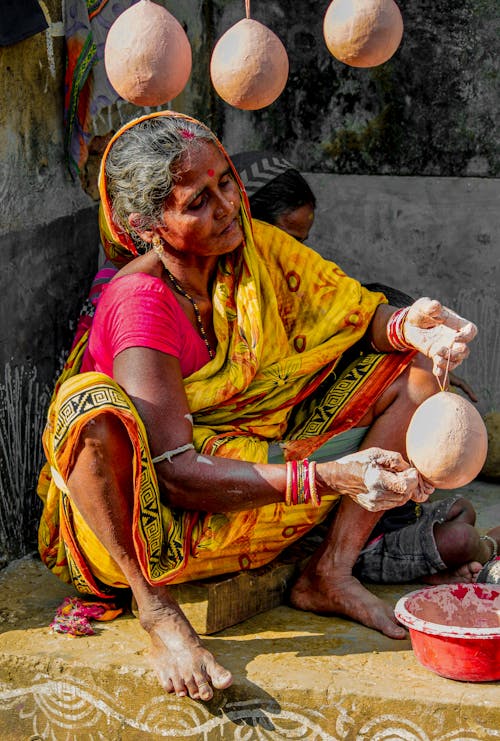 Free An old woman is making clay pots in a village Stock Photo