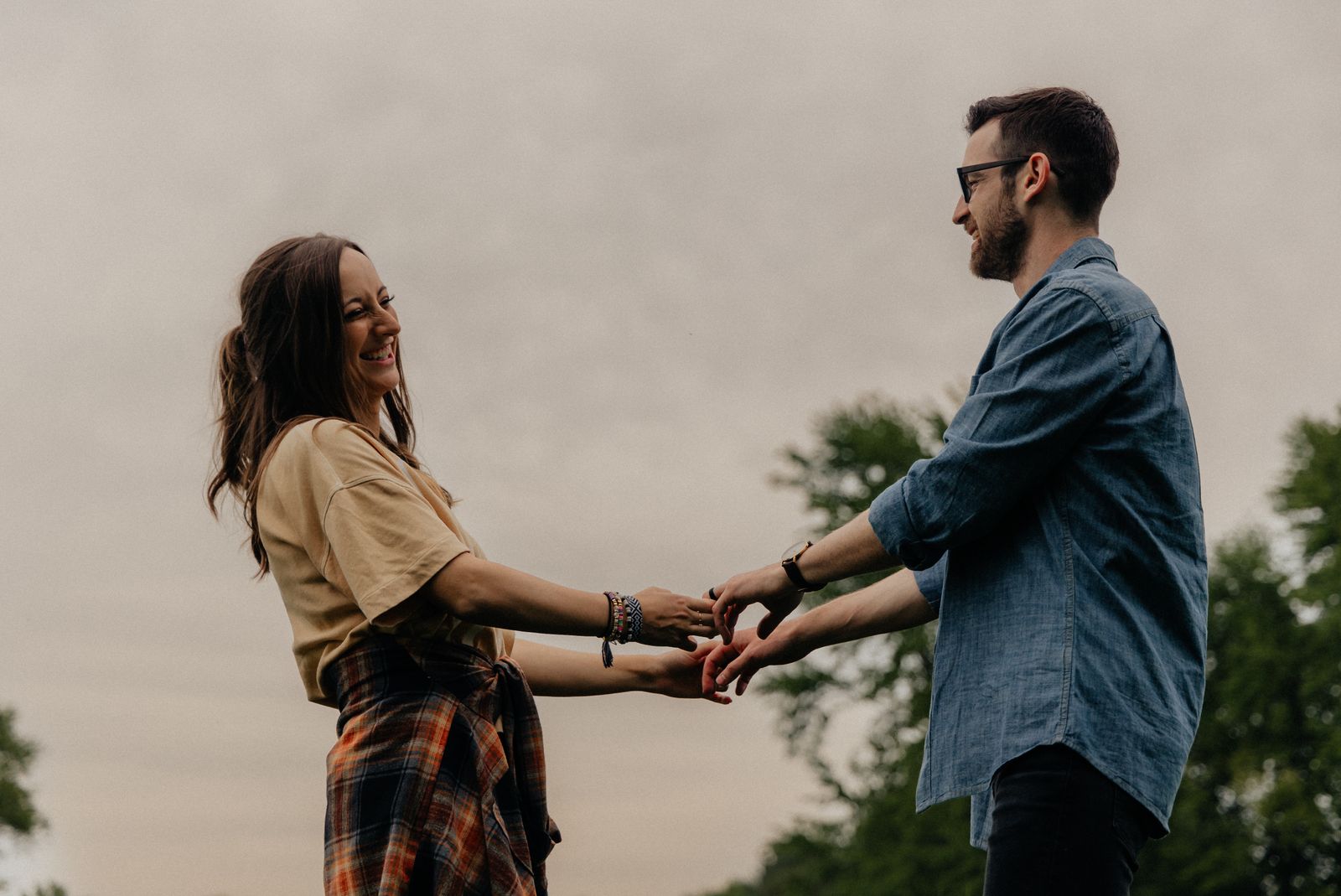Two people smiling and holding hands outdoors