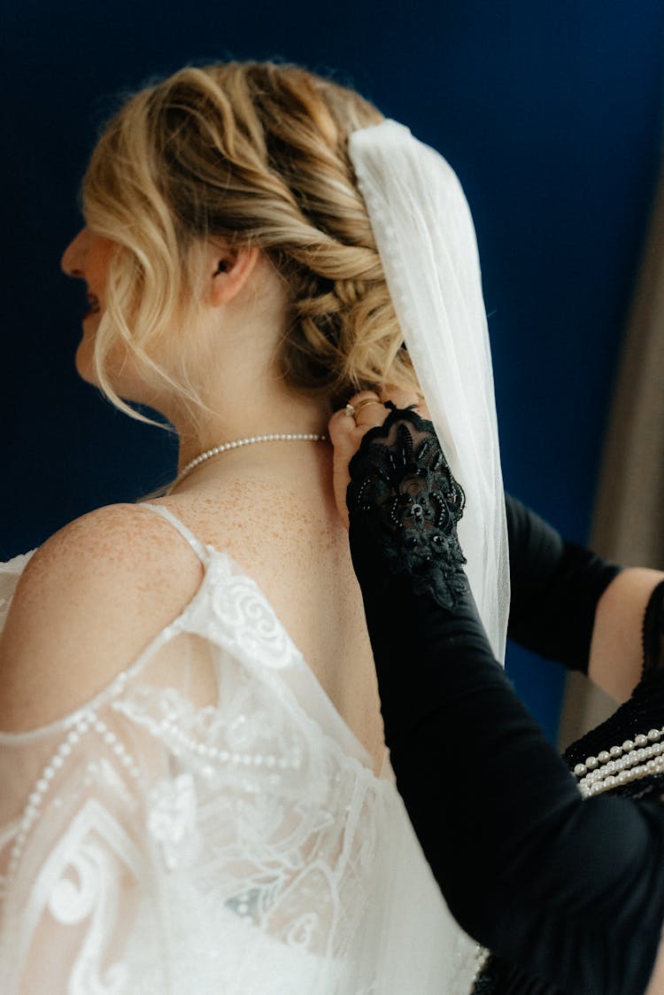 Bridesmaid Helping Bride With Necklace