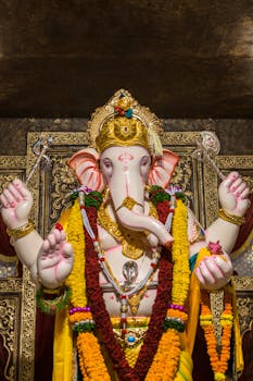 A magnificent statue of Lord Ganesha decorated with vibrant flowers and jewelry during a Hindu festival in Mumbai.