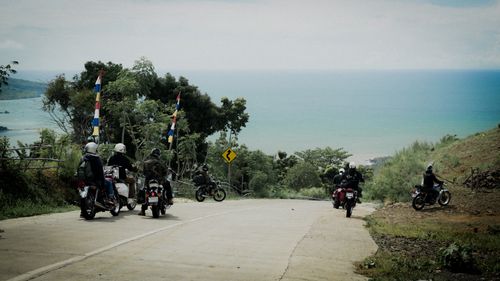Free Group of motorcyclists riding along a scenic coastal road with sea view. Stock Photo