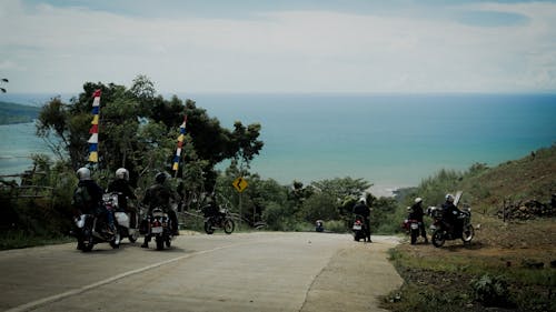 People on Motorbikes on Road on Hill on Sea Coast