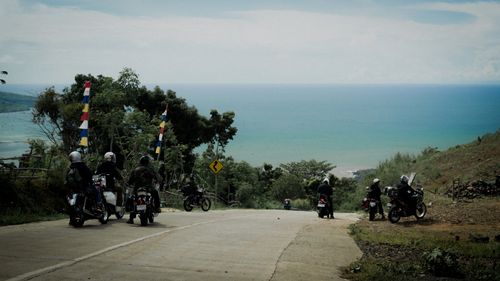 Free Group of motorcyclists riding on a rural road by the sea, scenic ocean view. Stock Photo
