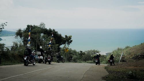 People on Motorbikes on Road on Hill