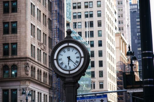 A classic clock tower amid skyscrapers in Manhattan, exuding urban elegance and time.