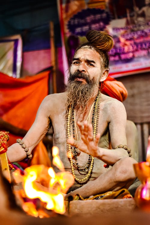 Sadhu Sitting on Ground by Bonfire