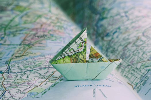Close-up of an origami boat placed on an open map, highlighting travel and exploration.