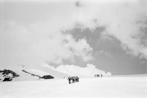 People Hiking on Hill in Mountains in Winter