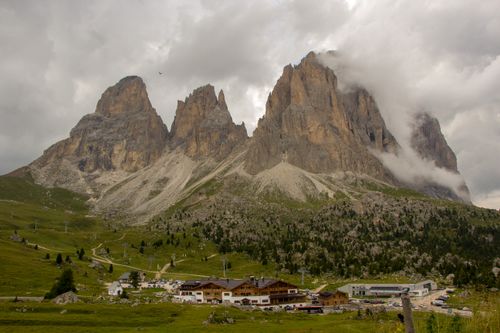 Free Breathtaking landscape of Dolomites with a quaint village nestled below the majestic peaks. Stock Photo