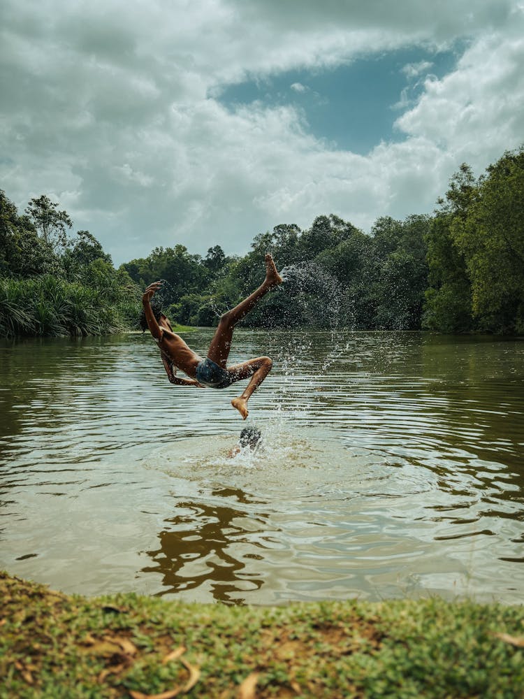 A Person Jumping Into A Lake