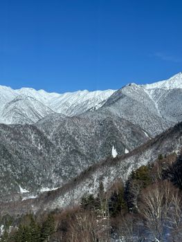 Breathtaking view of snow-covered mountains in Takayama, Japan on a clear winter day.