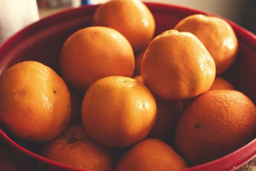Free Vibrant and fresh tangerines in a red bowl, ideal for food photography and citrus themes. Stock Photo