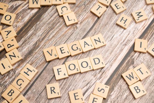 Vegan food on wooden table with scrabble letters