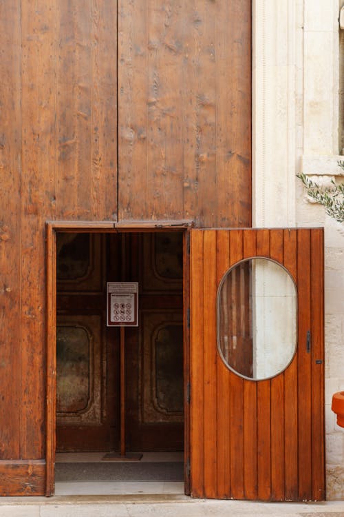 A wooden door with a round window in front of it