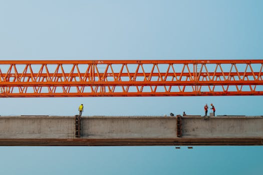Workers and red crane on a bridge construction in Chilmari, Bangladesh.