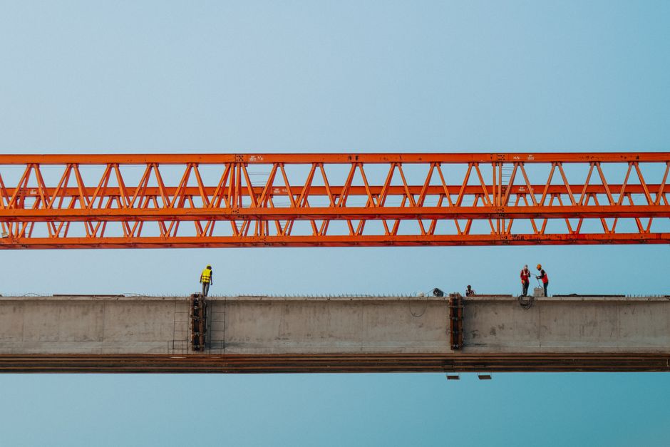 Workers and red crane on a bridge construction in Chilmari, Bangladesh.