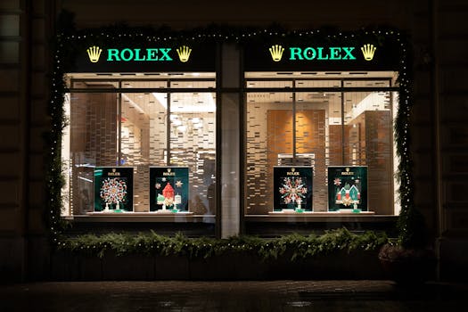Nighttime view of a Rolex store with festive Christmas decorations and lights.
