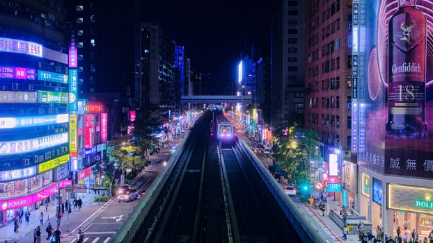 A vibrant view of Taipei's city streets at night, showcasing illuminated skyscrapers and urban life.