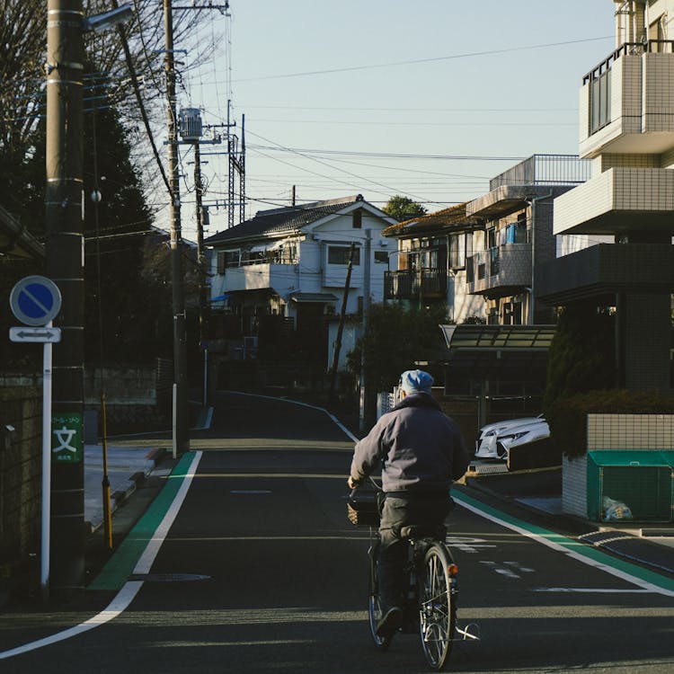 Senior Riding Bike On Street In Japan