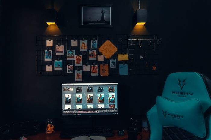 Dim workspace with monitors and a pinned mood board — photo by Lucas Andrade on Pexels
