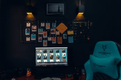 Free A computer desk with a blue chair and a black wall Stock Photo