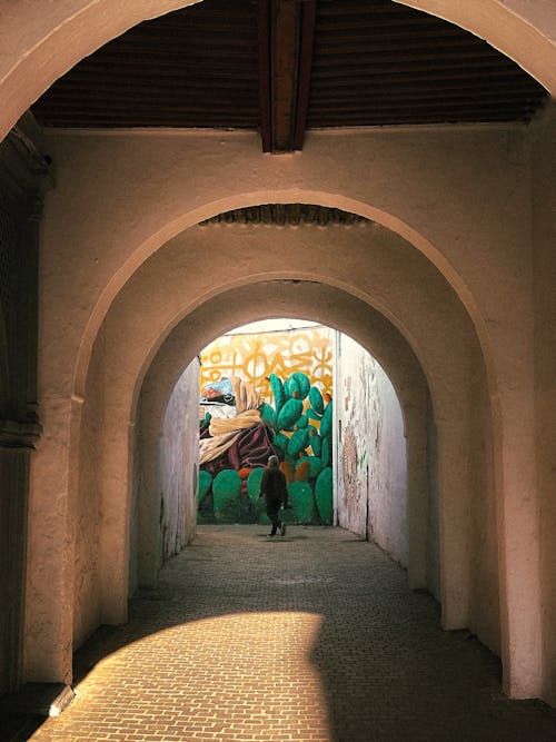 Person Walking in Tunnel in Town