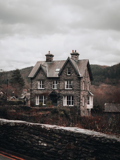 Free Picturesque stone cottage in Betws-y-Coed, Wales against a moody sky. Stock Photo
