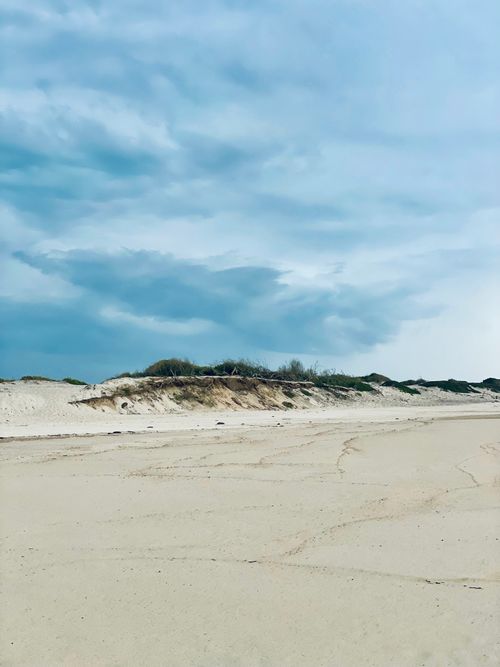 Free Peaceful beach view with sandy dunes and cloudy sky in Ovar, Portugal. Stock Photo