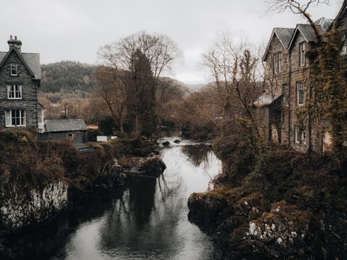 Free Charming riverside village view in Betws-y-Coed, Wales, showcasing scenic landscapes and architecture. Stock Photo