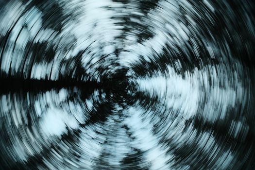 Dynamic fisheye view of a swirling snow-covered forest, creating a mesmerizing abstract pattern.