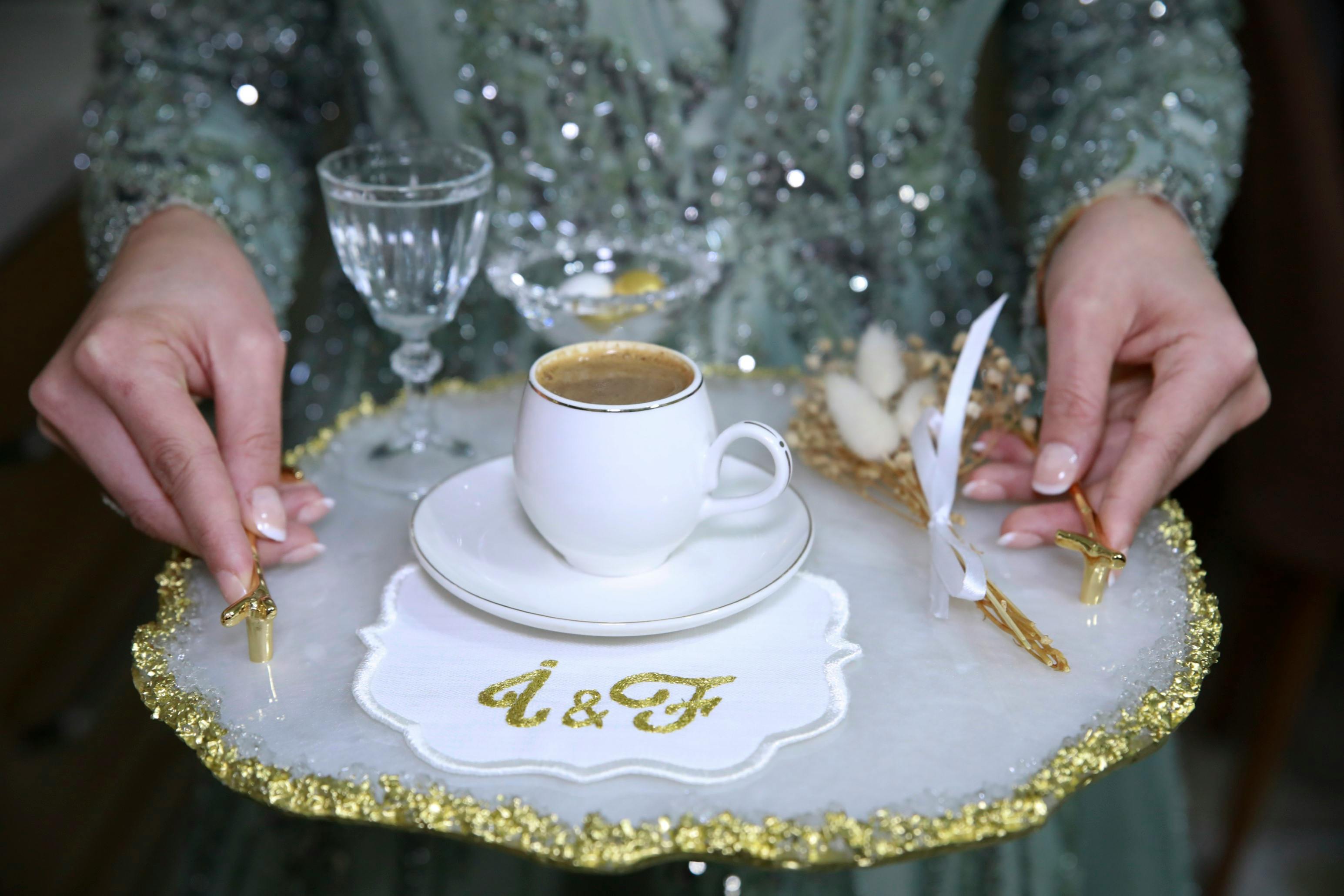 A woman holding a tray with a cup and a plate