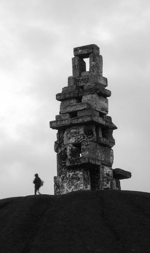 Free Black and white photo of a towering ancient stone monument with graffiti. Stock Photo