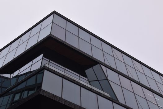 A striking modern building in Amsterdam with a reflective glass facade showcasing sleek architectural design.