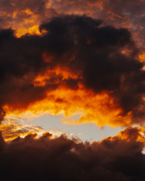 Free Vibrant sunset with dramatic red and orange clouds creating a striking sky scene. Stock Photo