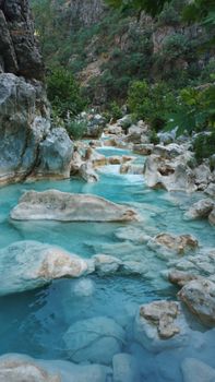A breathtaking view of a blue stream flowing through rocky canyon landscapes in Iraq.