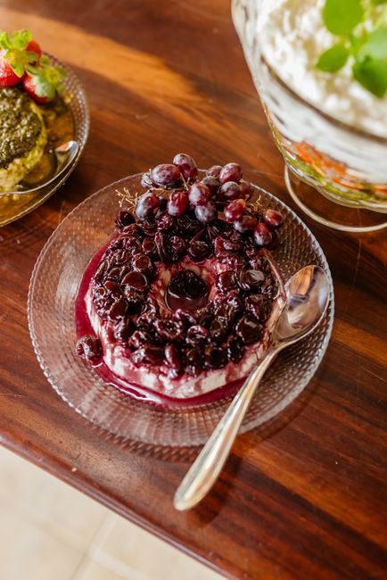 A glass dish of lemon-lime gelatin salad with halved red and green grapes suspended throughout, topped with chopped toasted pecans.