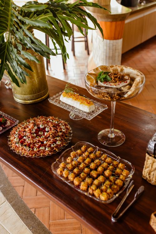 Free A lavish buffet display featuring appetizers, desserts, and gourmet dishes on a wooden table indoors. Stock Photo