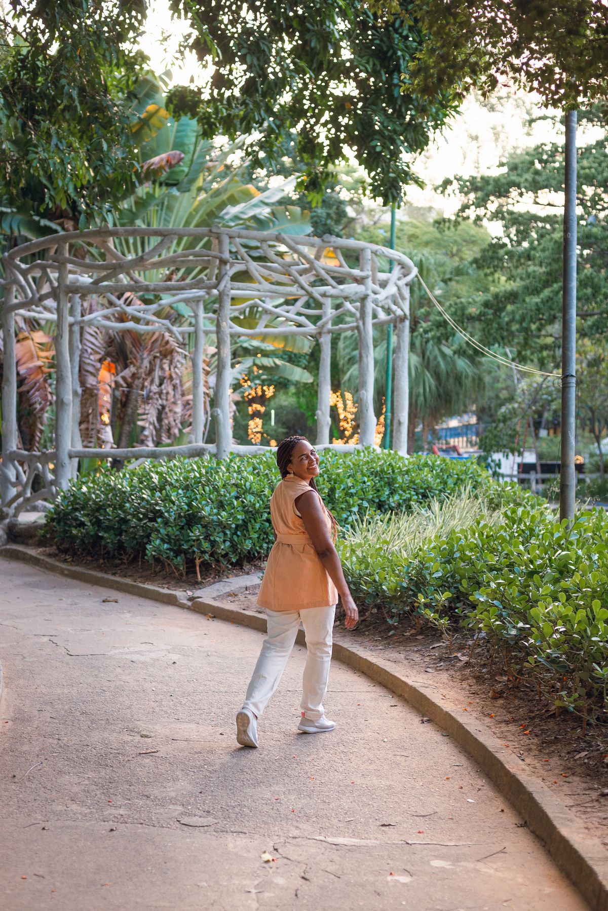 Mulher caminhando por um jardim tropical.