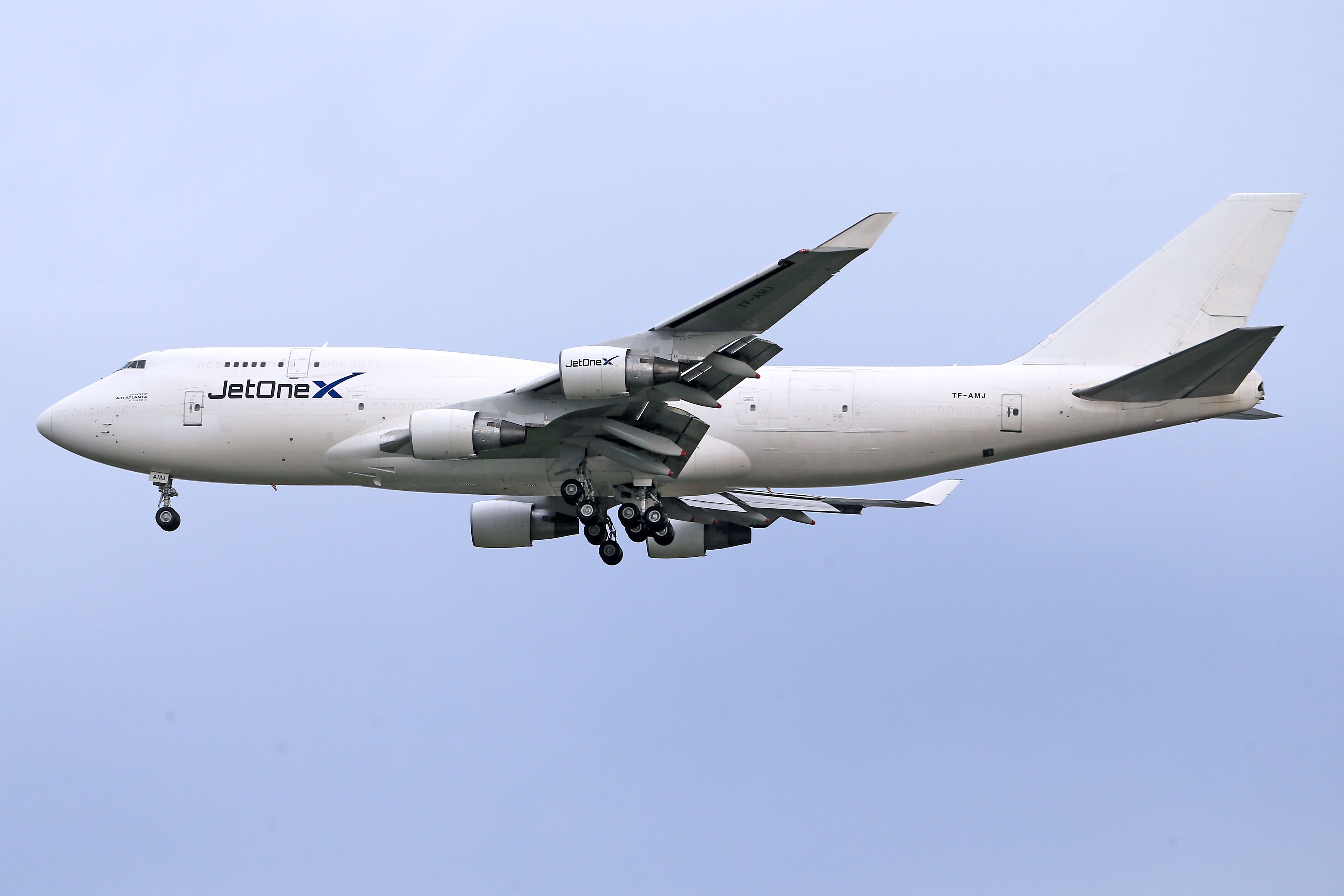 Side view of a JetOneX aircraft flying through the sky, showcasing its large wingspan.