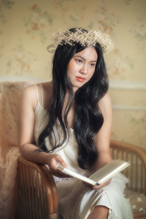 Woman in White Dress Sitting with Book on Armchair