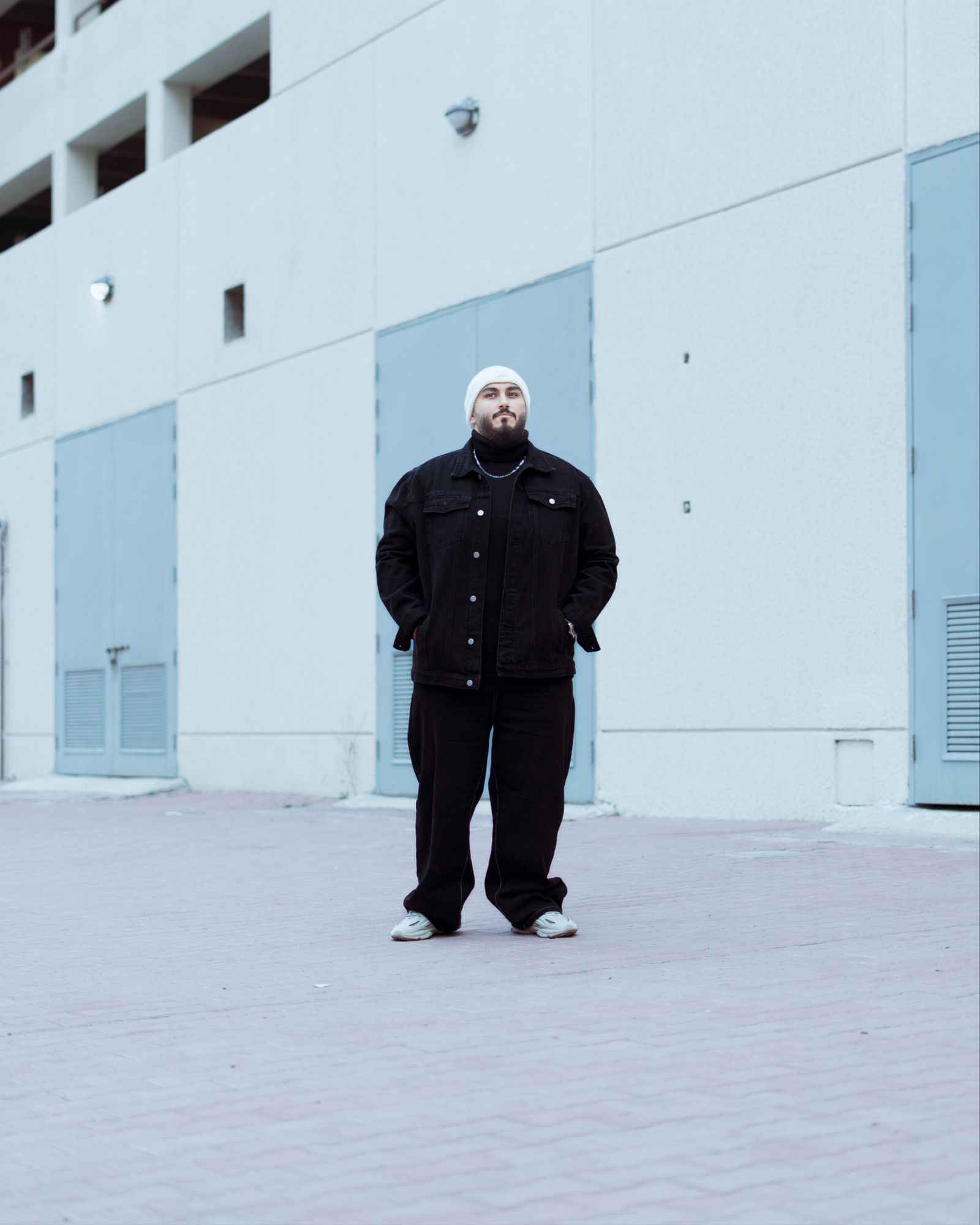 Homem vestindo conjunto preto em arquitetura urbana