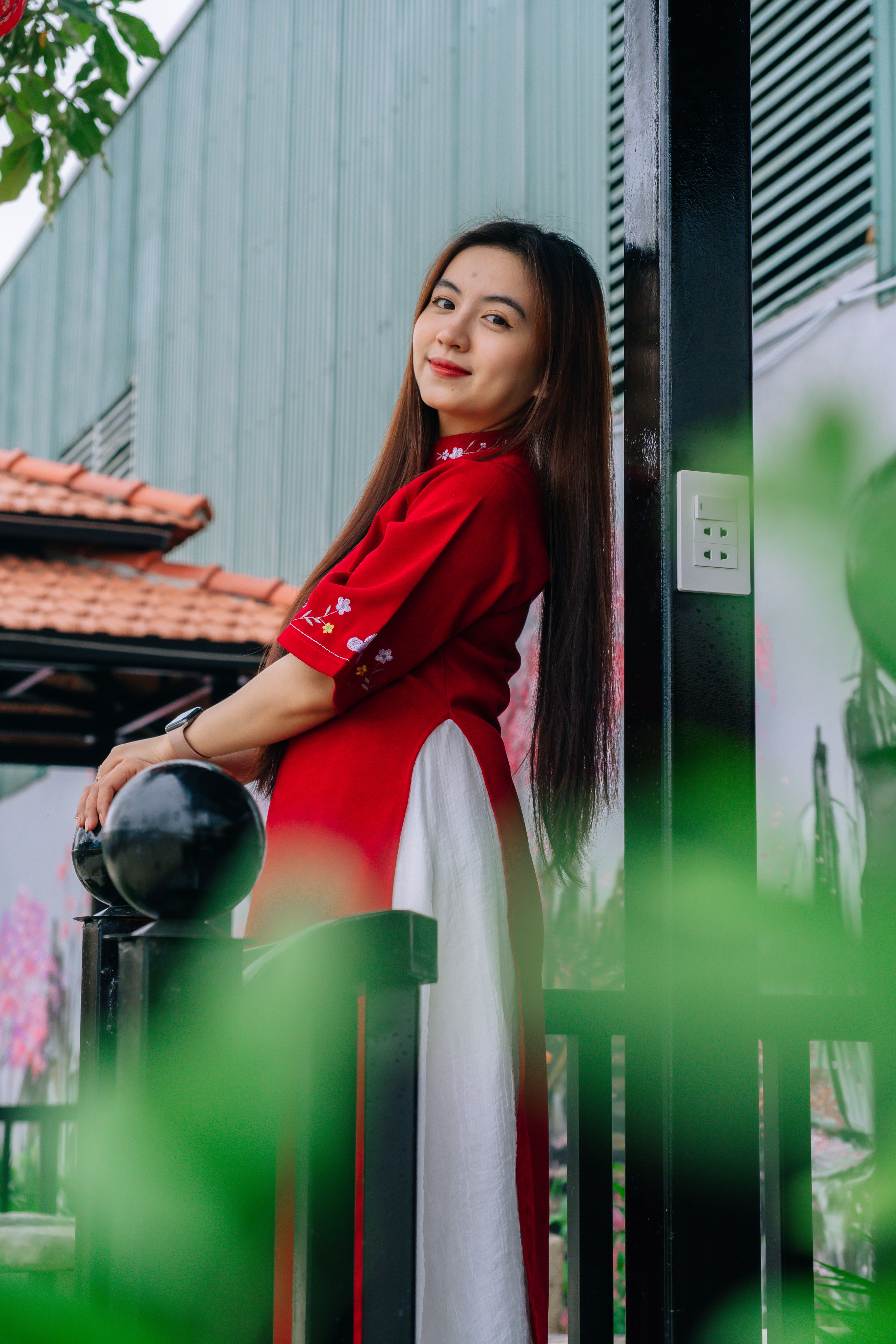 Elegant woman in traditional Ao Dai dress posing on a sunny day.
