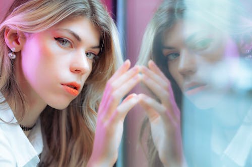 Free Young Woman Standing next to a Window  Stock Photo