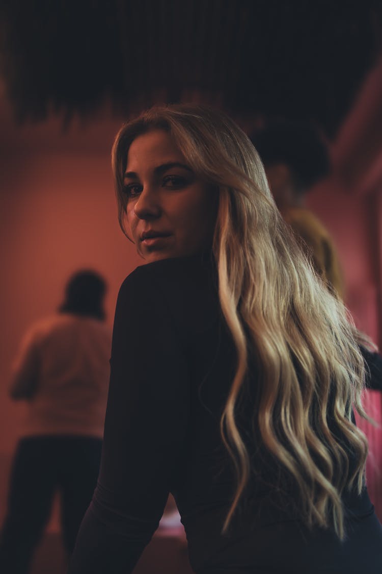 Young Woman With Long Hair Looking Over Her Shoulder In A Club 