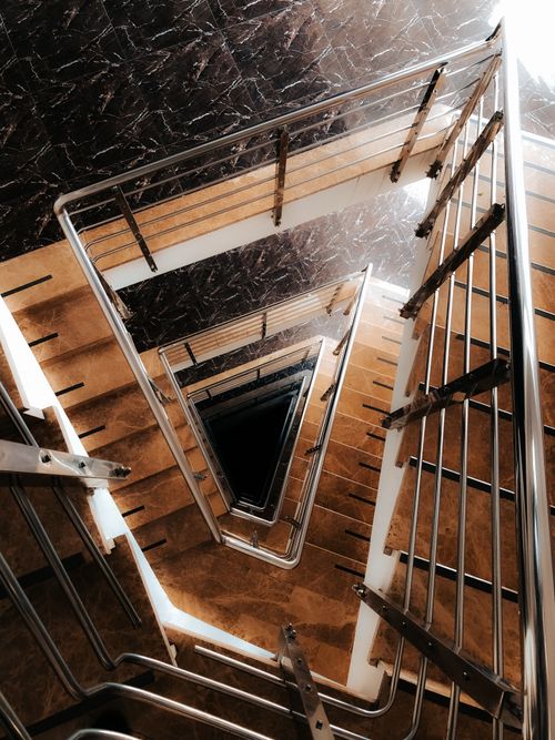 Free Vertical shot of a contemporary spiral staircase with metal railings. Stock Photo