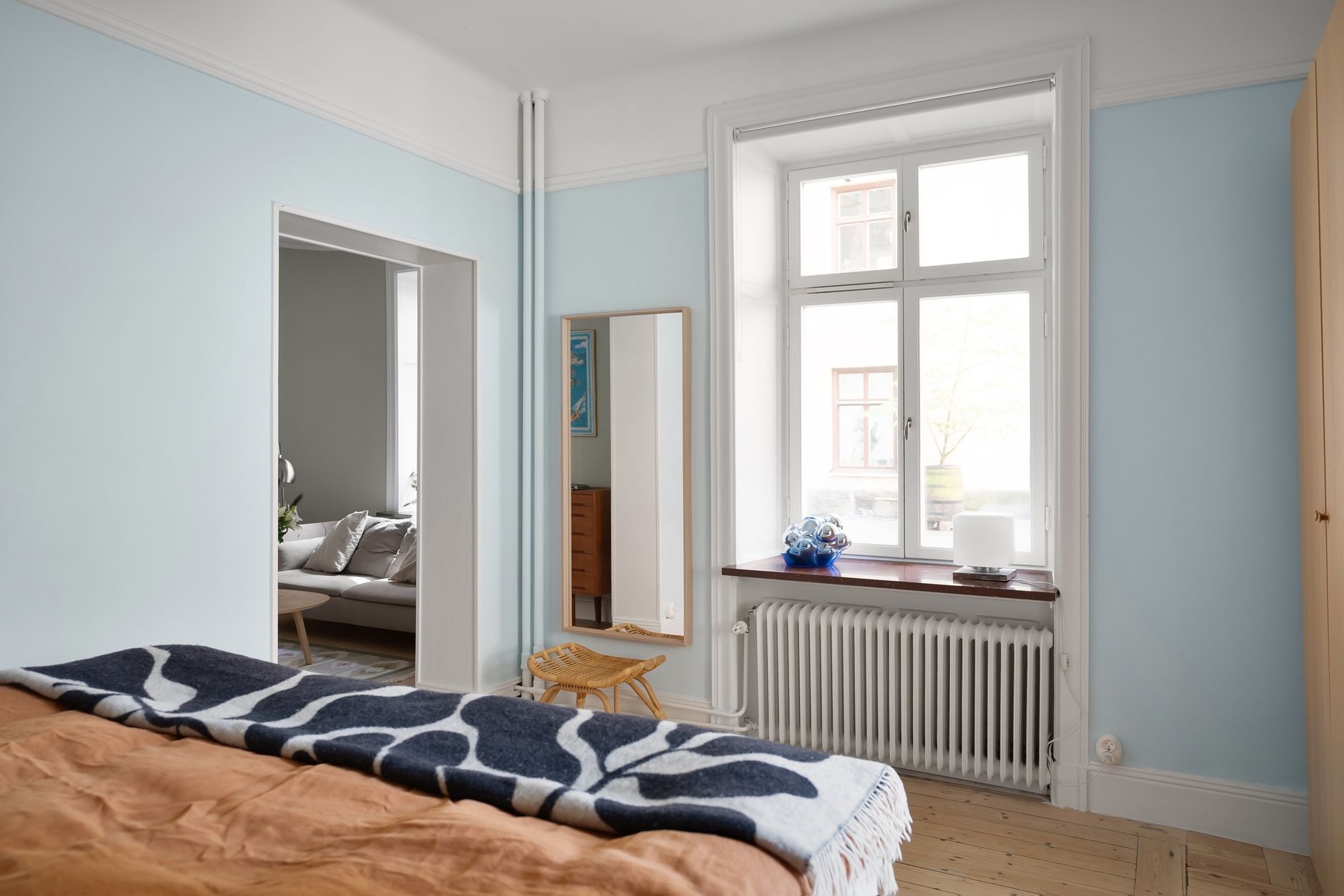Tranquil bedroom with pastel decor and ample natural light, showcasing minimalist design.